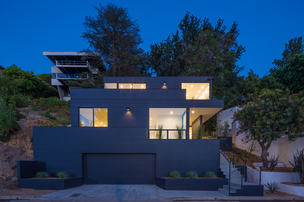 Diseño de fachada de casa negra moderna de tamaño medio de tres plantas con revestimiento de aglomerado de cemento, tejado plano y techo verde