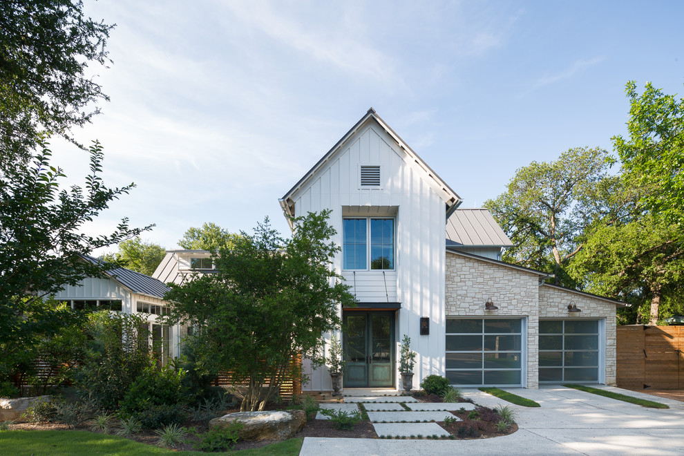Идея дизайна: двухэтажный, белый частный загородный дом в стиле кантри с комбинированной облицовкой, двускатной крышей и металлической крышей
