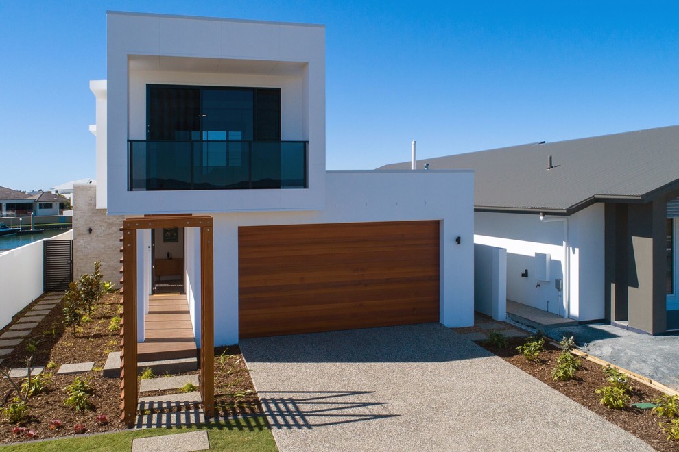 Inspiration pour une façade de maison blanche design de plain-pied avec un toit plat.