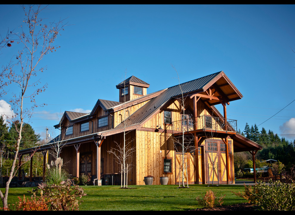 Ejemplo de fachada marrón de estilo de casa de campo grande de tres plantas con revestimiento de madera y tejado a dos aguas