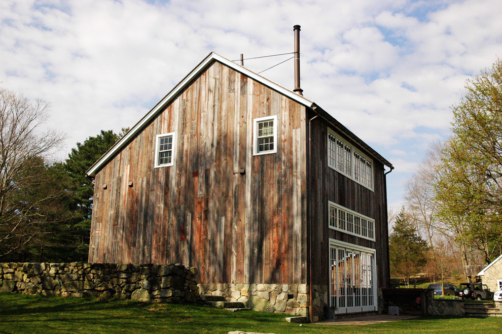 Photo of a farmhouse two floor house exterior in Boston with wood cladding.