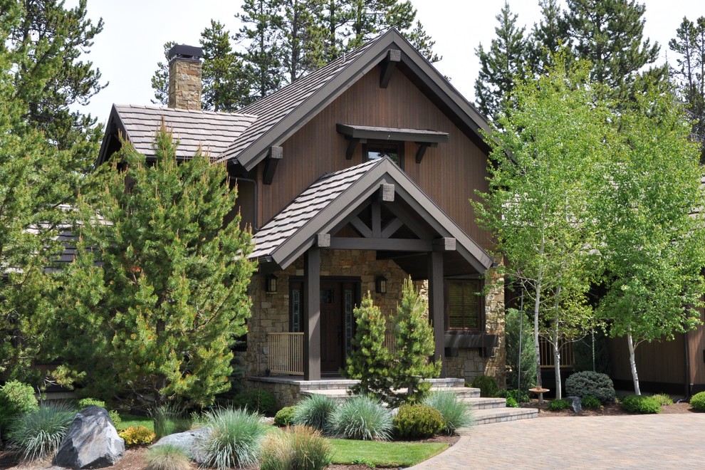 Réalisation d'une grande façade de maison marron chalet avec un toit à deux pans.