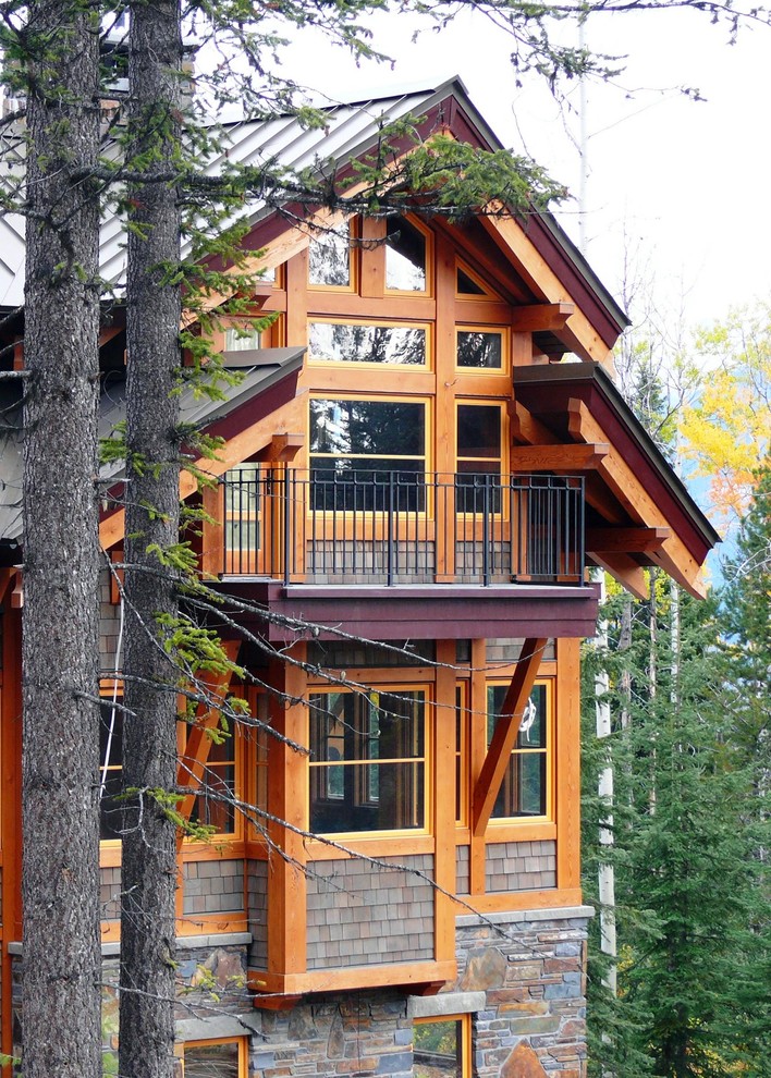 Пример оригинального дизайна: двухэтажный, коричневый дом в стиле рустика с комбинированной облицовкой и двускатной крышей