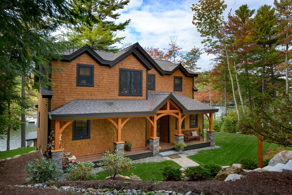На фото: двухэтажный, деревянный, большой, коричневый частный загородный дом в стиле рустика с двускатной крышей и крышей из гибкой черепицы