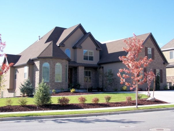 Cette photo montre une grande façade de maison marron chic à deux étages et plus avec un revêtement mixte et un toit à croupette.