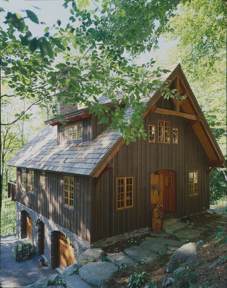 Immagine della facciata di una casa piccola marrone rustica a tre piani con rivestimento in legno e tetto a capanna
