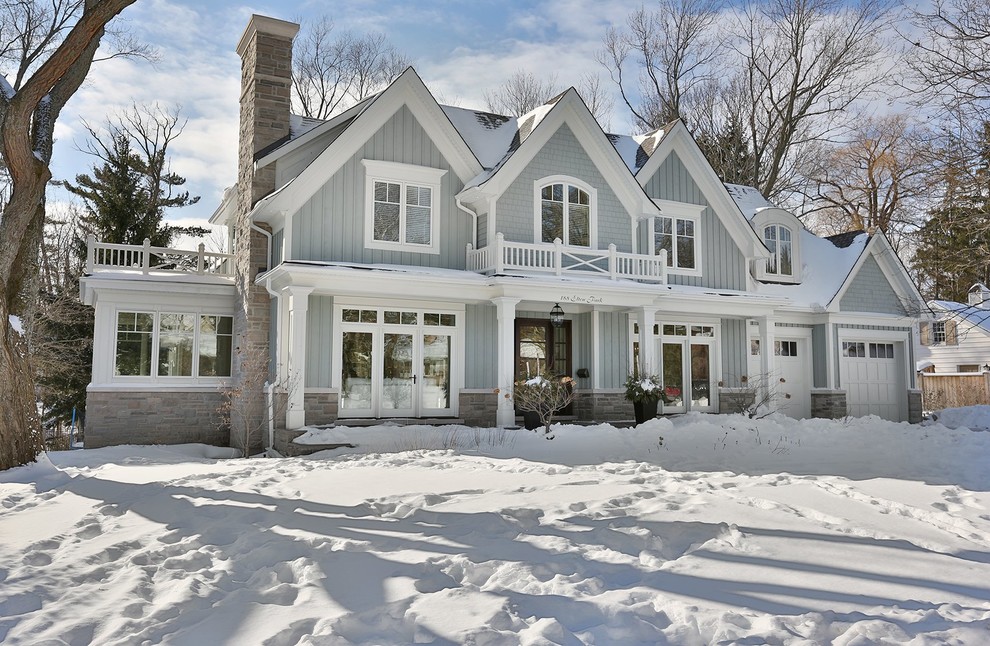 Large traditional blue two-story wood exterior home idea in Toronto