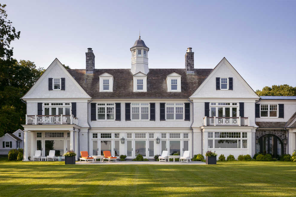 Esempio della facciata di una casa ampia bianca stile marinaro a tre piani con rivestimento in legno e copertura a scandole