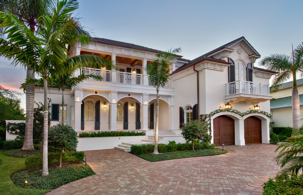 Diseño de fachada de casa blanca tropical de dos plantas con tejado a dos aguas