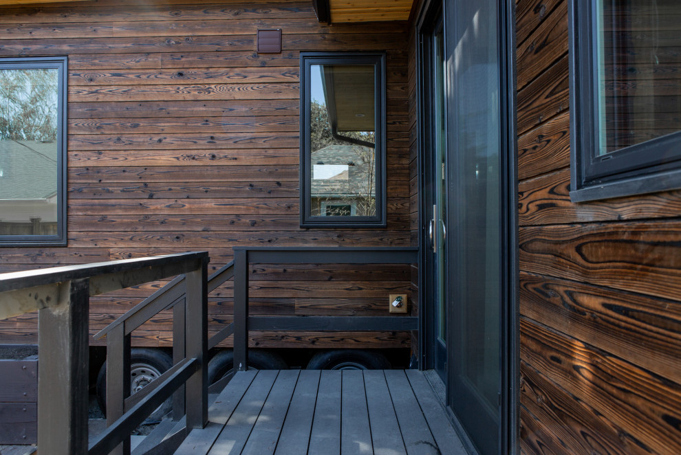 Immagine della facciata di un appartamento piccolo marrone moderno a un piano con rivestimento in legno, tetto piano e copertura in metallo o lamiera