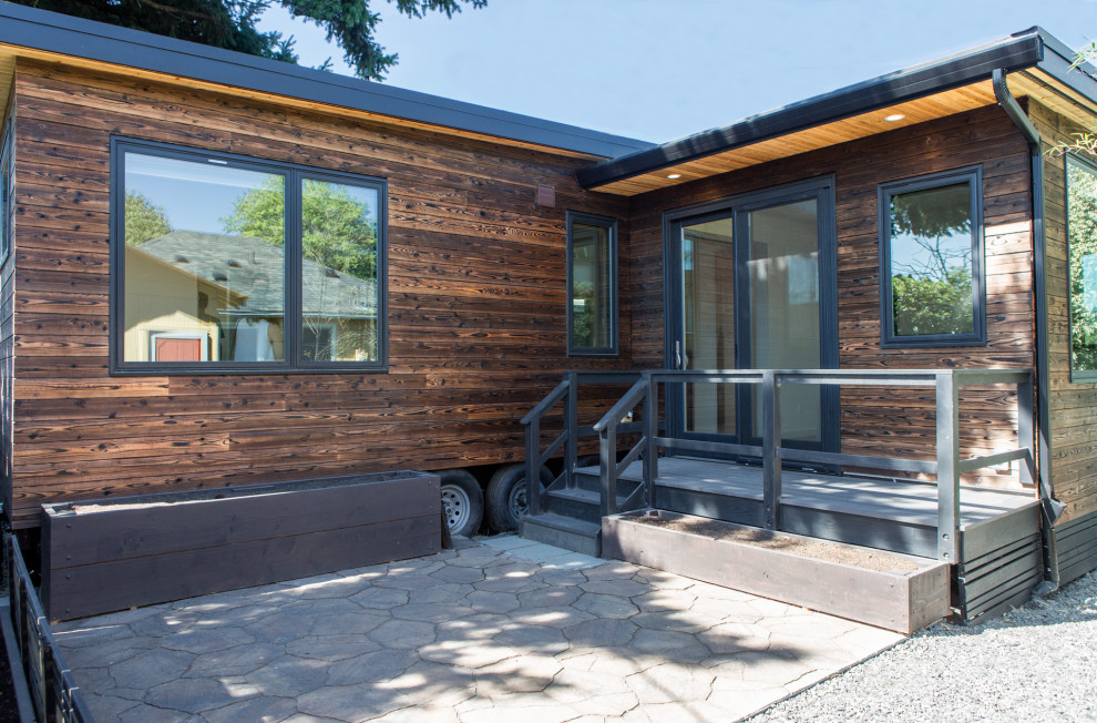 Idée de décoration pour un petite façade d'immeuble minimaliste en bois avec un toit plat et un toit en métal.