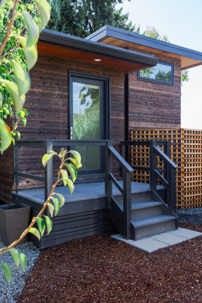 Источник вдохновения для домашнего уюта: маленький, одноэтажный, деревянный, коричневый многоквартирный дом в стиле модернизм с плоской крышей и металлической крышей для на участке и в саду