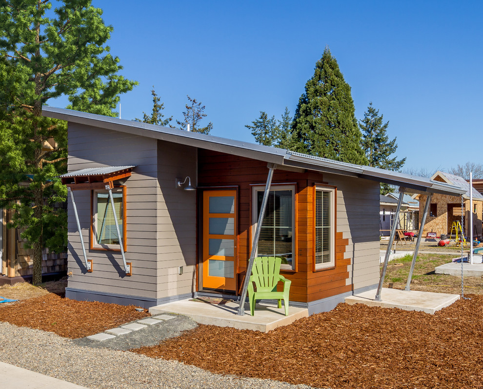 Cette photo montre une petite façade de Tiny House grise tendance en bois de plain-pied avec un toit en appentis et un toit en métal.