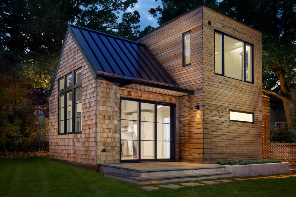 Diseño de fachada de casa marrón tradicional renovada pequeña de dos plantas con revestimiento de madera, tejado a dos aguas y tejado de metal