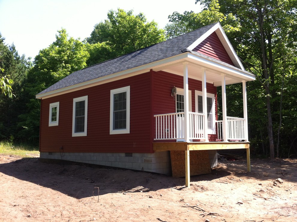 Foto della facciata di una casa piccola rossa classica a un piano con rivestimento in vinile