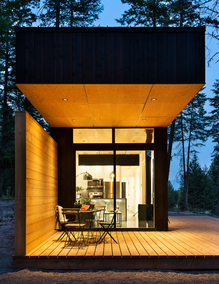 Idée de décoration pour une façade de maison noire chalet en bois de taille moyenne et de plain-pied avec un toit en appentis et un toit en métal.