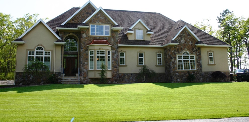 На фото: огромный, двухэтажный, коричневый дом в классическом стиле с облицовкой из цементной штукатурки