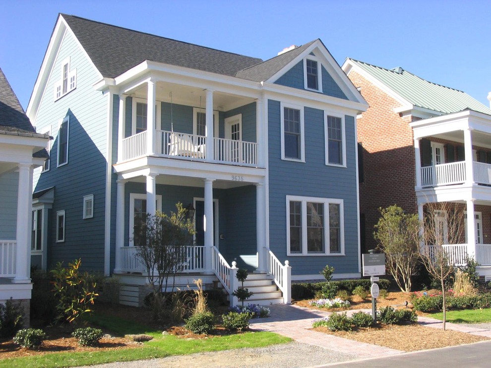 Пример оригинального дизайна: двухэтажный, синий дом среднего размера в морском стиле с комбинированной облицовкой и двускатной крышей