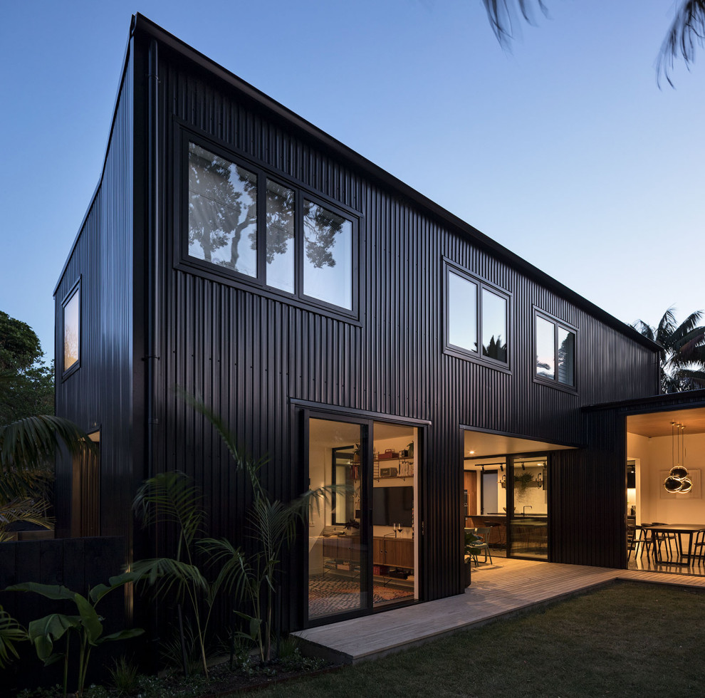 Large contemporary black two-story metal exterior home idea in Auckland with a metal roof