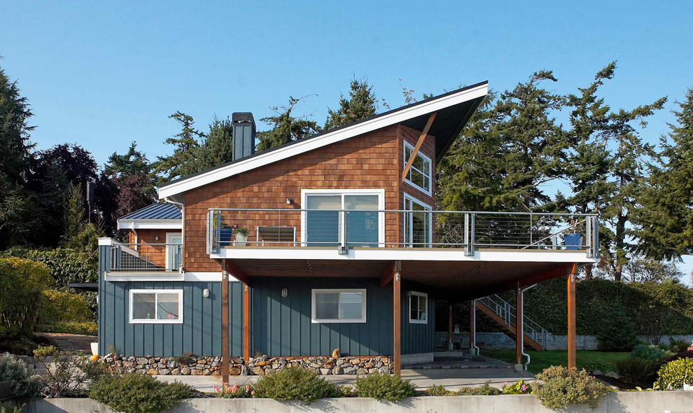 Immagine della casa con tetto a falda unica blu contemporaneo con rivestimento in legno