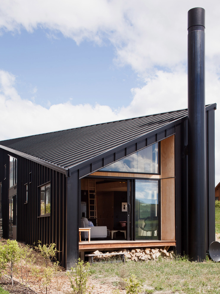 Inspiration pour une petite façade de maison métallique et noire minimaliste à un étage avec un toit à deux pans.
