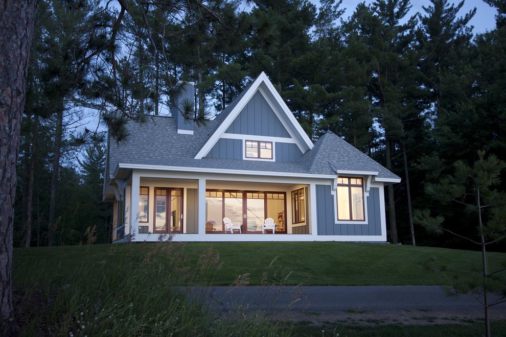 На фото: маленький, двухэтажный, деревянный дом в стиле неоклассика (современная классика) с двускатной крышей для на участке и в саду