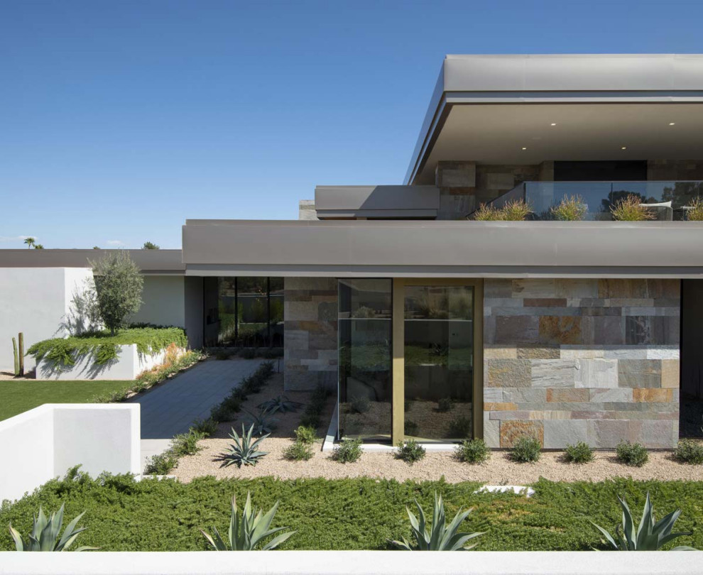 Huge contemporary gray two-story stone exterior home idea in Phoenix with a gray roof