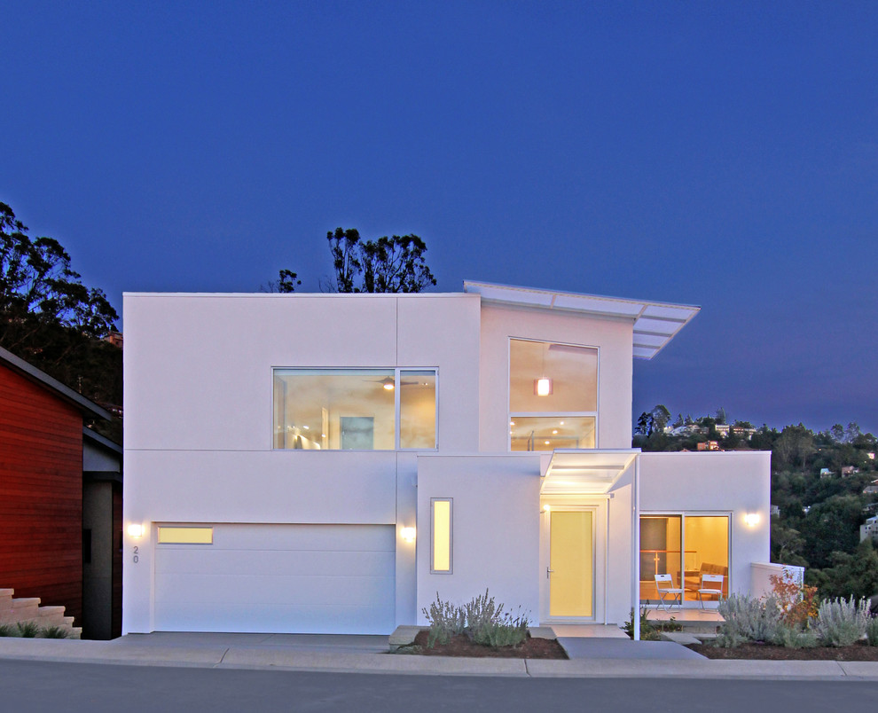 Diseño de fachada blanca moderna de tamaño medio de dos plantas con revestimiento de estuco y tejado plano