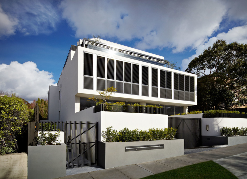 Modelo de fachada blanca contemporánea grande de tres plantas con revestimiento de hormigón