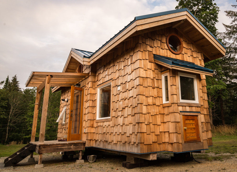 Immagine della villa piccola marrone american style a un piano con rivestimento in legno, tetto a capanna e copertura in metallo o lamiera
