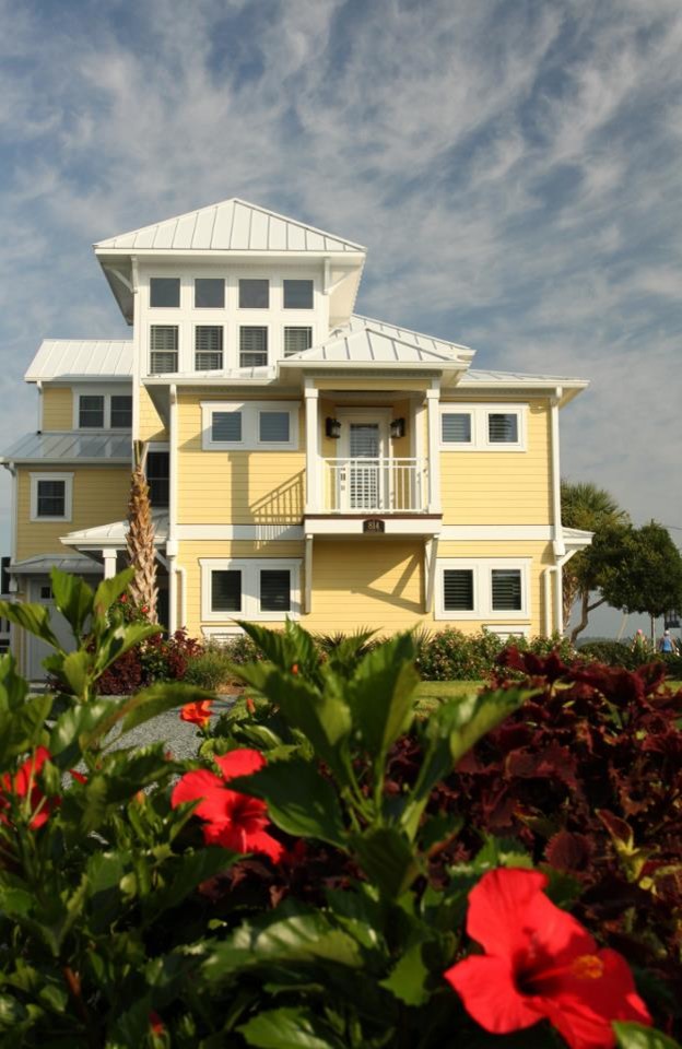 Foto della facciata di una casa gialla stile marinaro a tre piani con rivestimento con lastre in cemento