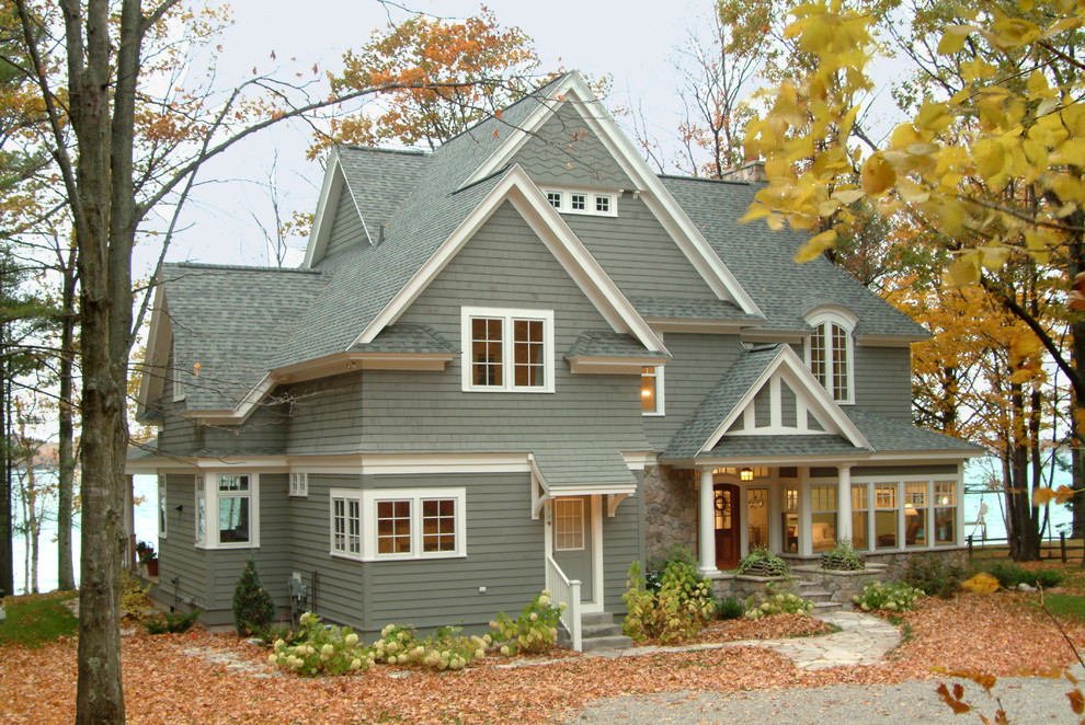 Esempio della villa grande grigia american style a due piani con rivestimento in legno, tetto a capanna e copertura a scandole