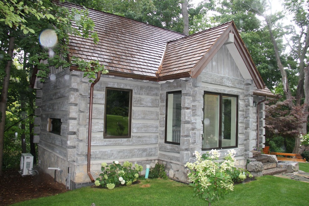 Foto della facciata di una casa piccola grigia rustica a un piano con tetto a capanna