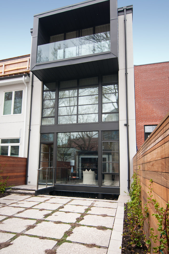 На фото: трехэтажный, черный дом среднего размера в современном стиле с облицовкой из цементной штукатурки