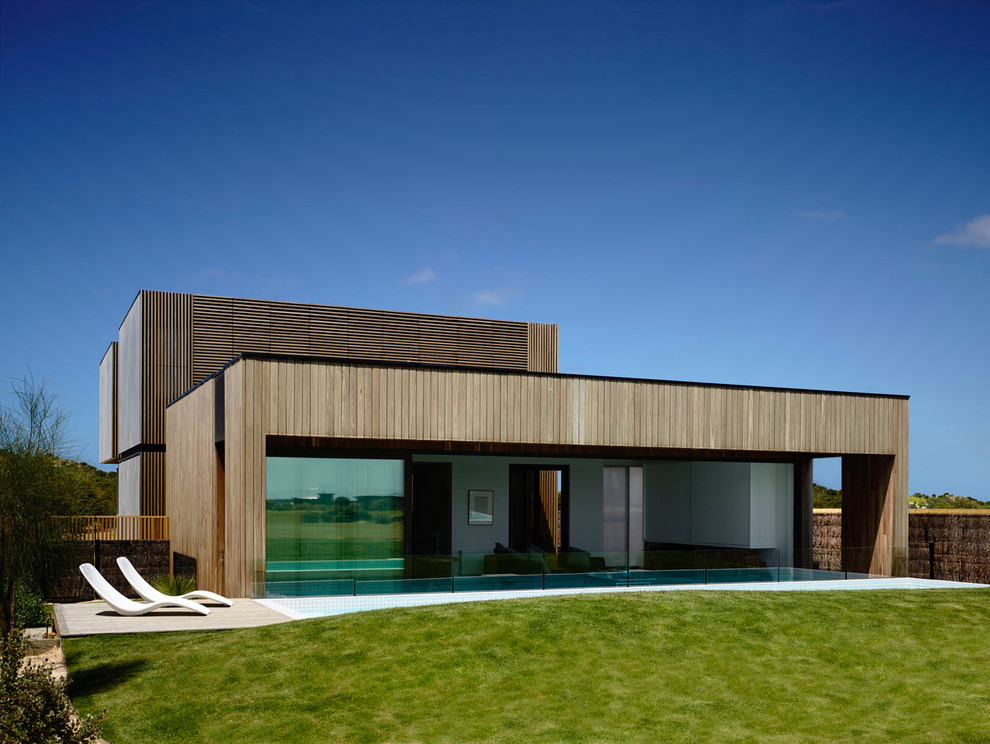 Large trendy two-story wood flat roof photo in Melbourne