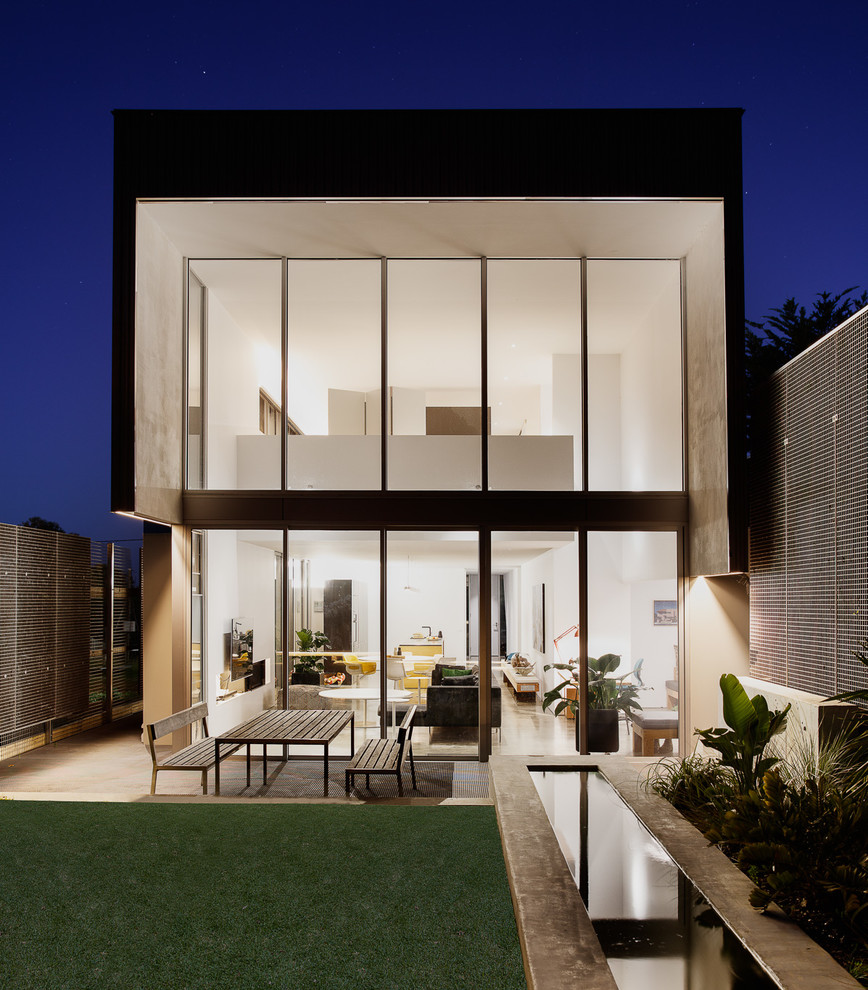 Imagen de fachada minimalista de tamaño medio de dos plantas con revestimiento de hormigón y tejado plano