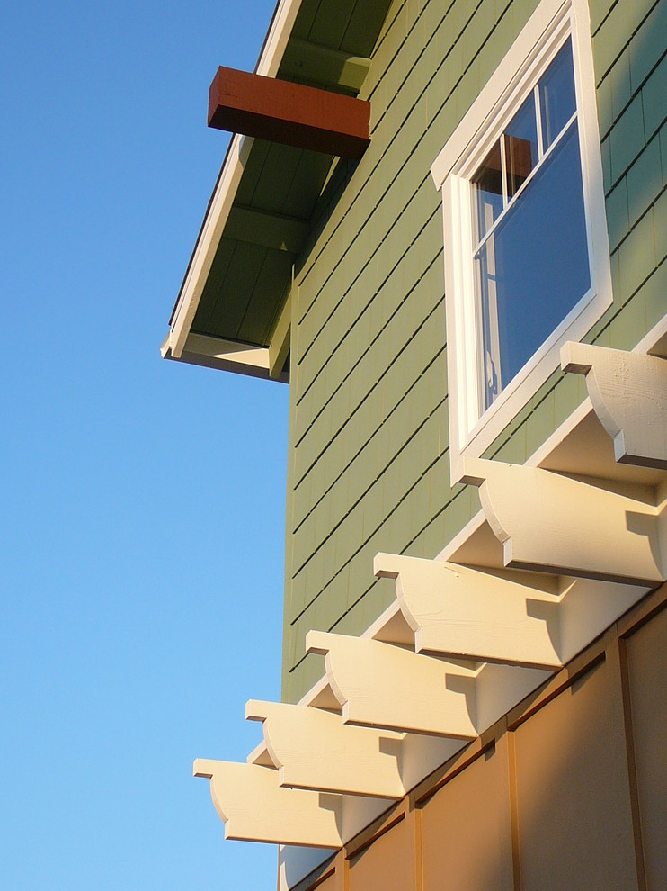 Cette photo montre une façade de maison verte craftsman en panneau de béton fibré de taille moyenne et à un étage avec un toit à deux pans.