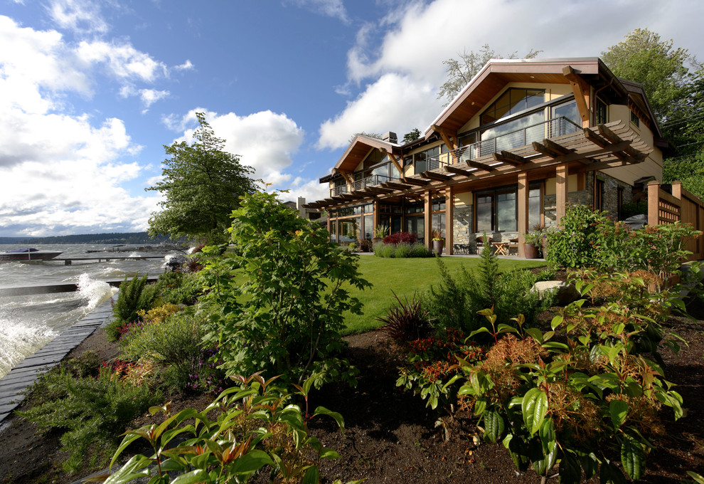 Diseño de fachada de casa multicolor de estilo americano de dos plantas con revestimientos combinados y tejado a dos aguas