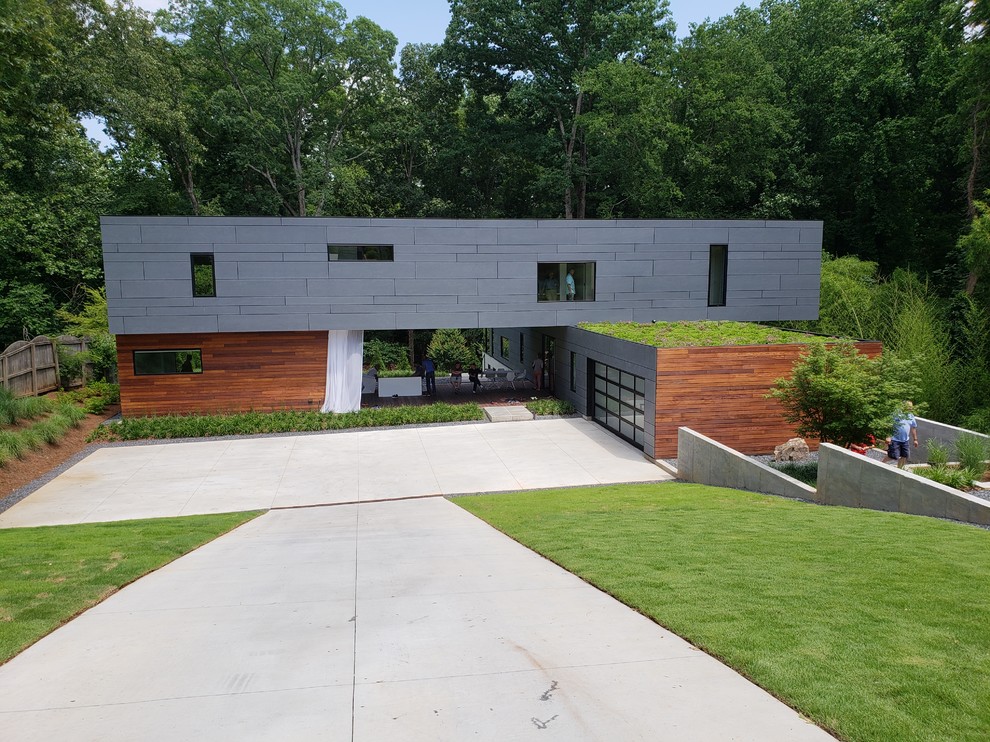 Inspiration pour une façade de maison grise design à un étage avec un toit plat.