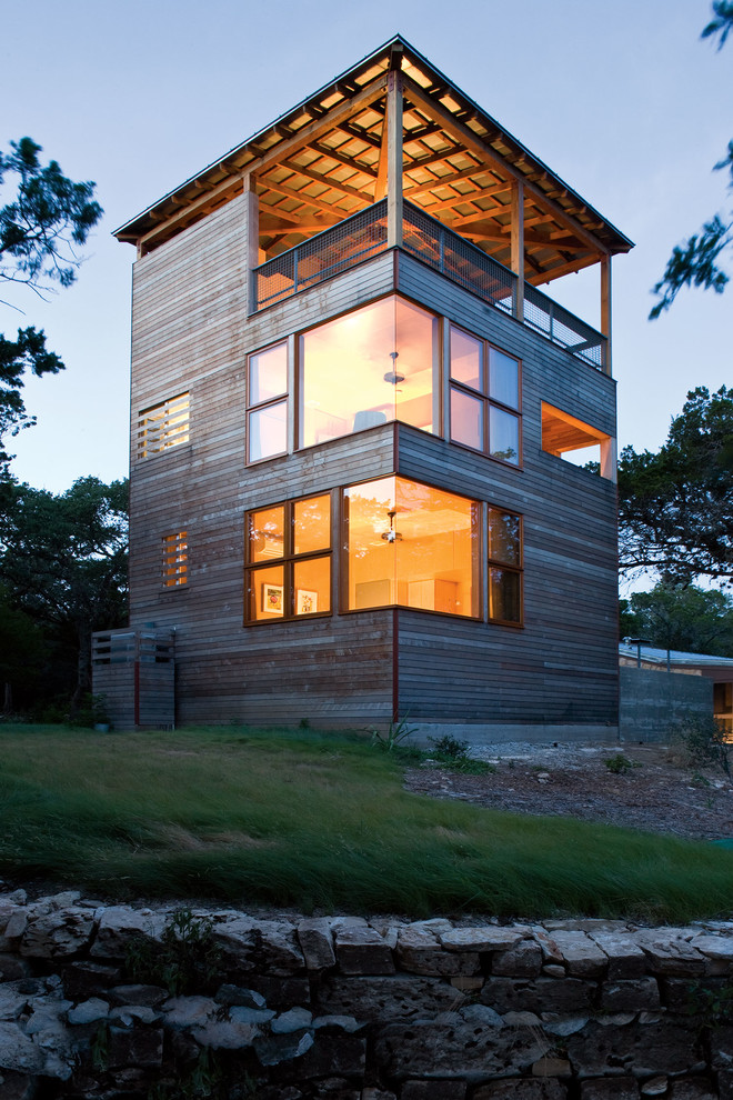 Diseño de fachada marrón contemporánea de tres plantas con revestimiento de madera y tejado plano