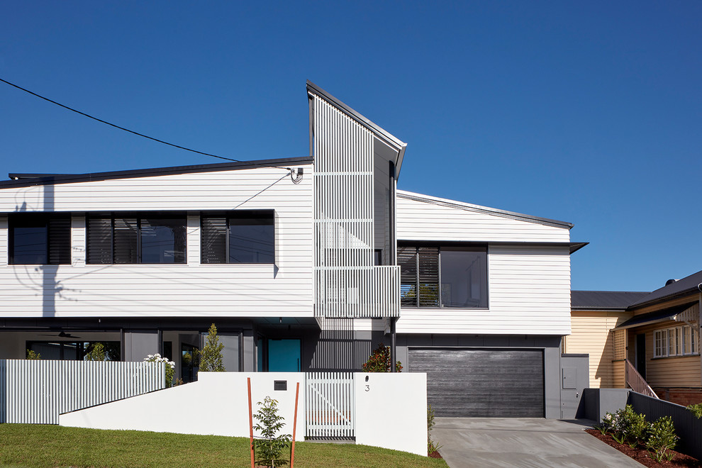 Mid-sized trendy white two-story house exterior photo in Brisbane with a metal roof