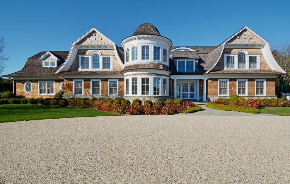 Стильный дизайн: двухэтажный, деревянный, коричневый дом в морском стиле с мансардной крышей - последний тренд