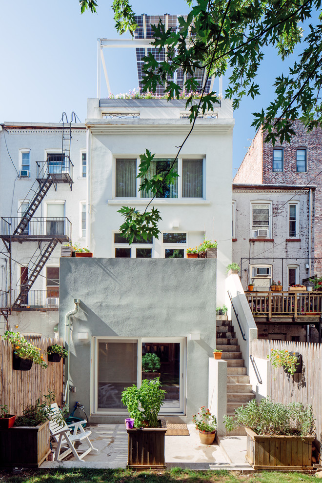 Example of a transitional white three-story stucco exterior home design in New York