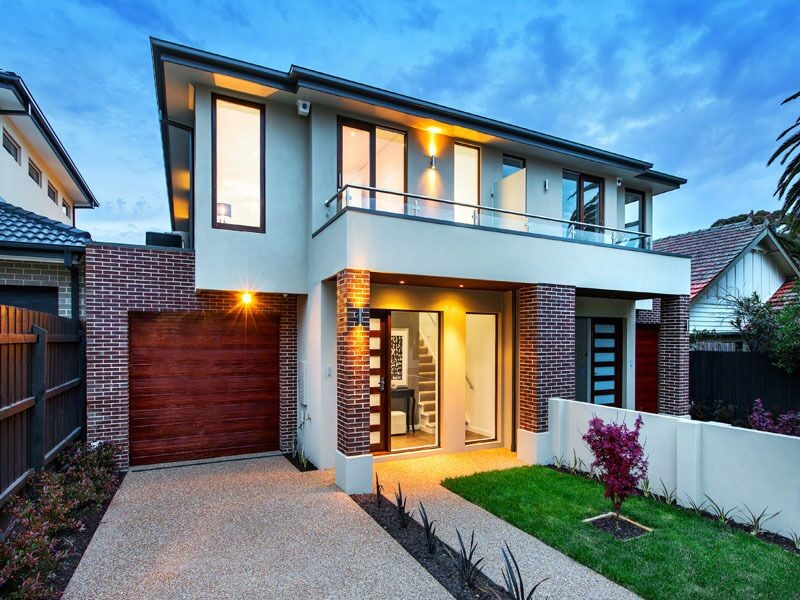 Large and beige contemporary two floor render terraced house in Melbourne with a pitched roof and a metal roof.