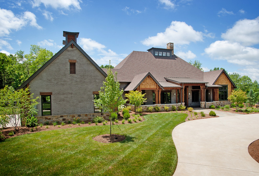 Large and beige contemporary two floor brick house exterior in Nashville with a hip roof.