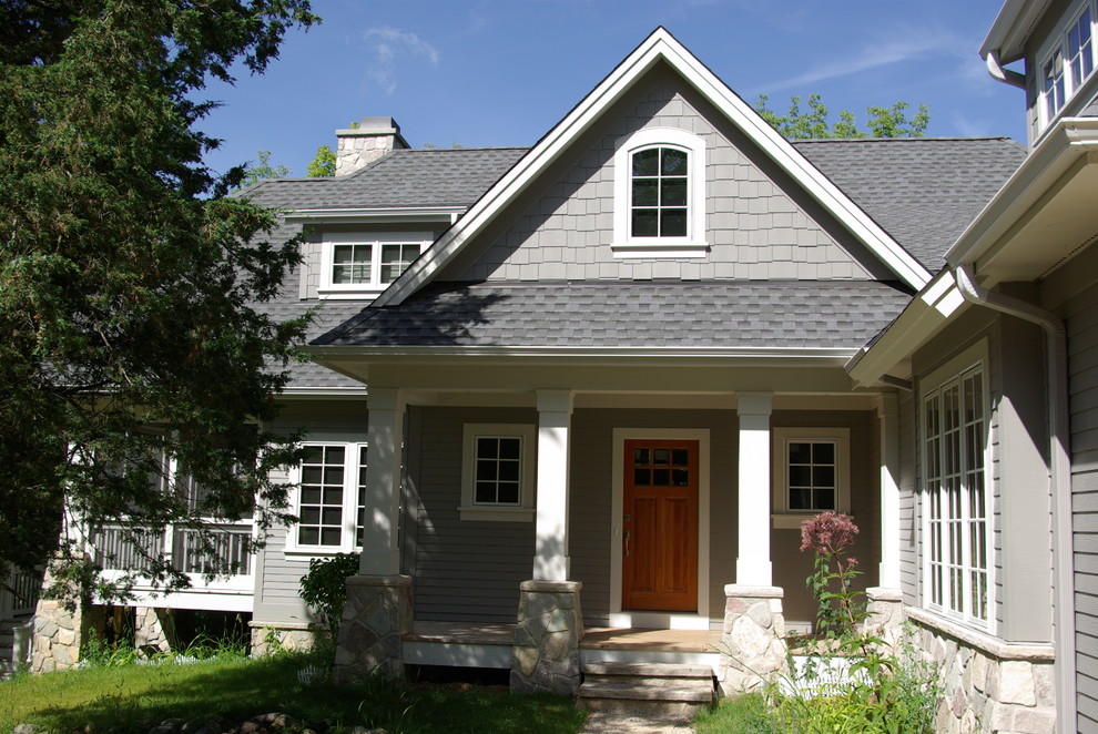 На фото: двухэтажный, серый, деревянный дом среднего размера в классическом стиле с двускатной крышей