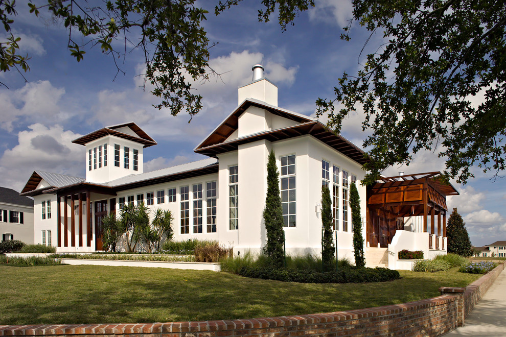 Ispirazione per la facciata di una casa grande bianca tropicale a due piani con rivestimento in stucco e tetto a capanna