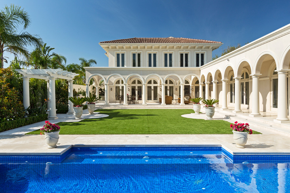 На фото: большой, двухэтажный, белый дом в средиземноморском стиле с вальмовой крышей с