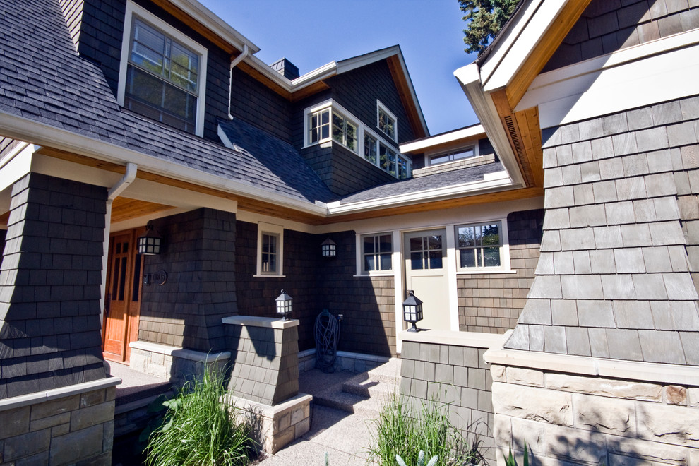 Inspiration for a brown traditional two floor house exterior in Calgary with wood cladding and a pitched roof.
