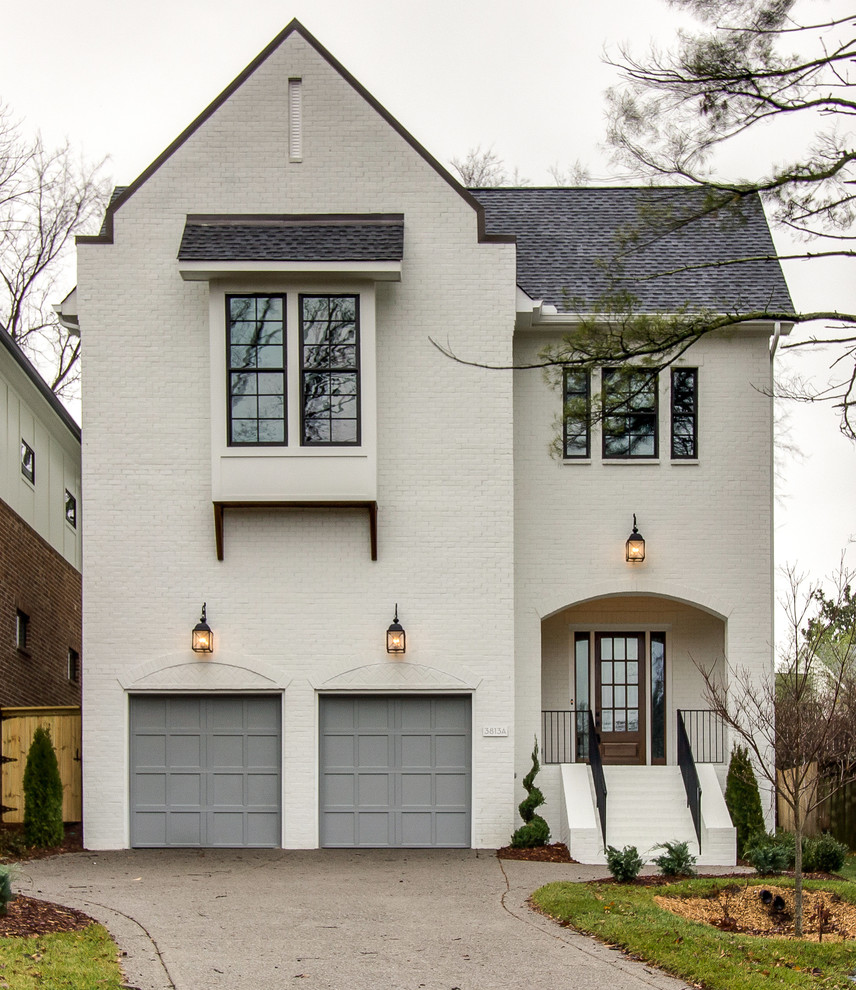 Large traditional white two-story brick exterior home idea in Nashville with a shingle roof
